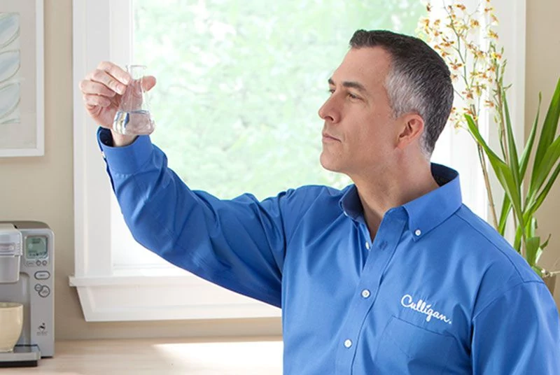 Culligan employee swirling water in beaker Culligan employee swirling water in beaker