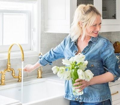 girl watering flowers at sink