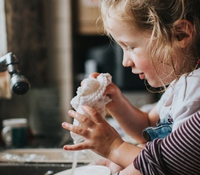 mother and daughter doing dishes at sink