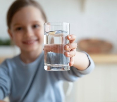 girl holding glass of water