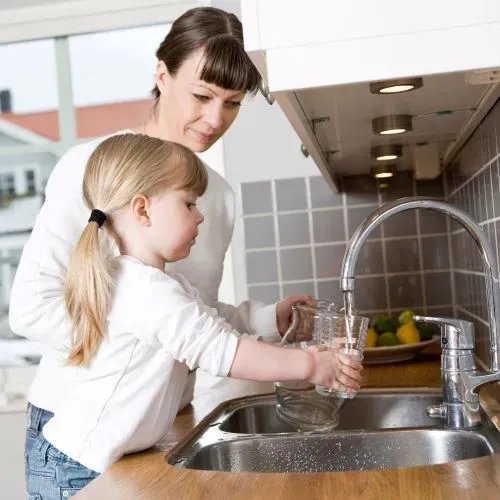 Mother and child at kitchen sink